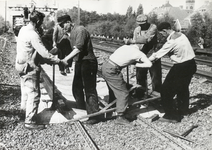 168967 Afbeelding van wegwerkers van de N.S. tijdens het leggen van betonnen dwarsliggers op het proefbaanvak (3e ...